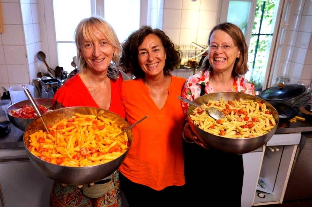Volunteers in the Open Sky House kitchen with pasta bowls